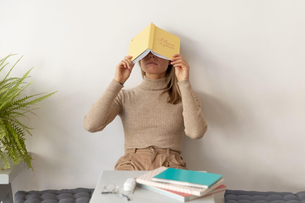 Chica estresada con libros y un libro en la cabeza, simbolizando la presión por memorizar sin técnicas efectivas.